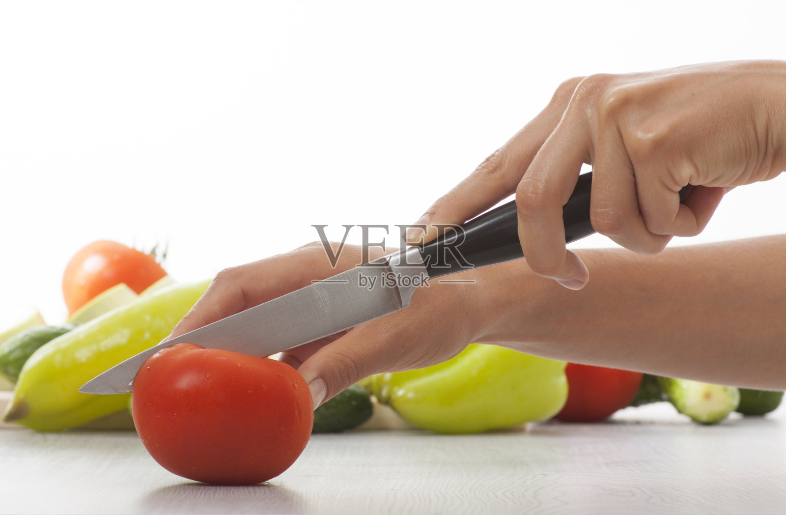 女性用刀，切西红柿照片摄影图片