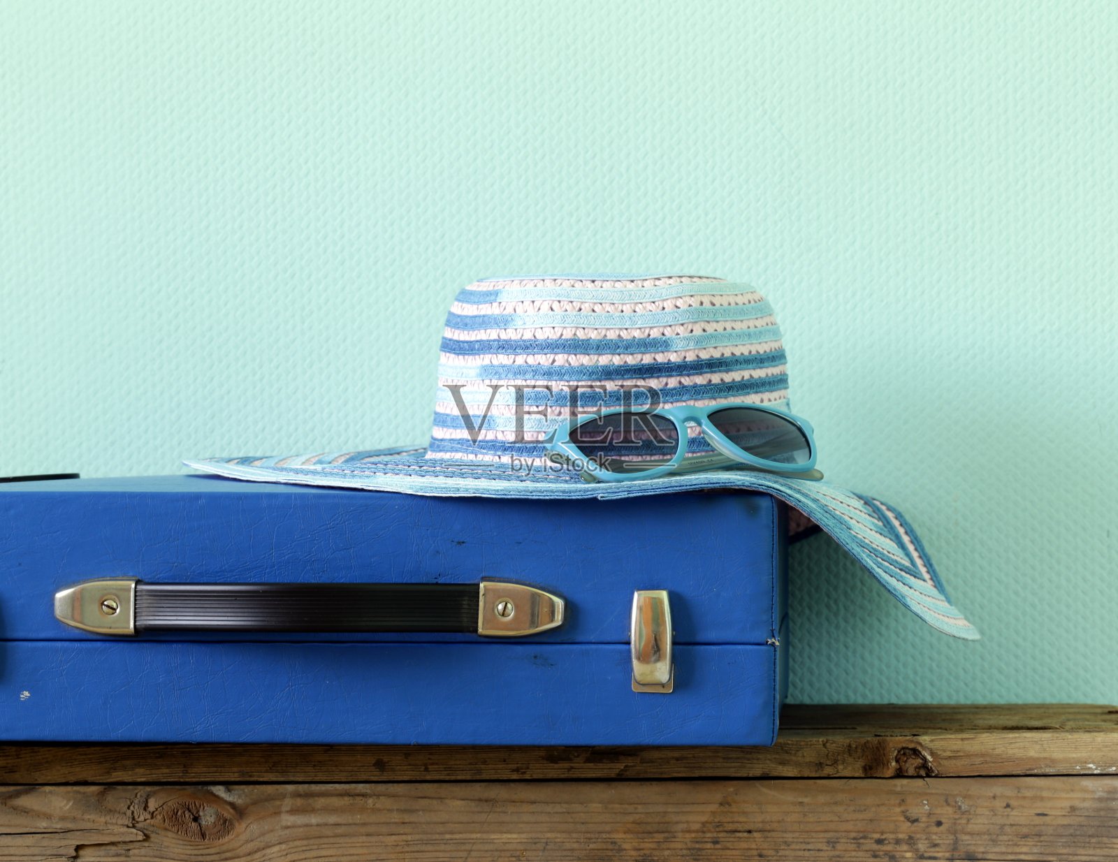 老式的蓝色旅行箱和沙滩帽照片摄影图片