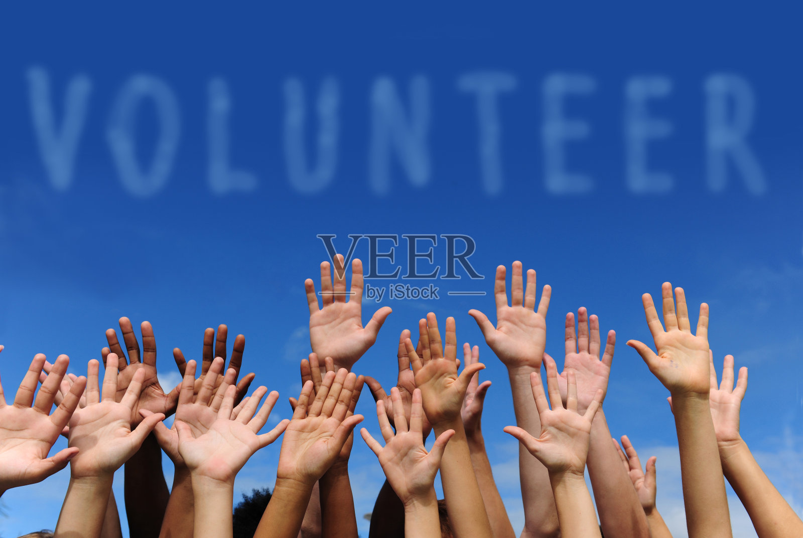 在“志愿者”一词下举起多只手照片摄影图片