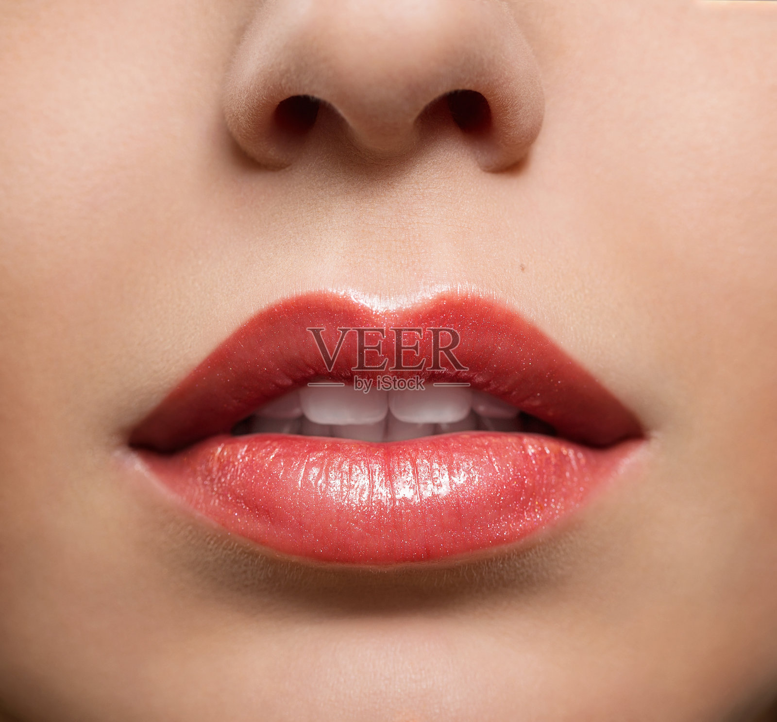 女性嘴唇的特写，涂着光滑的口红照片摄影图片