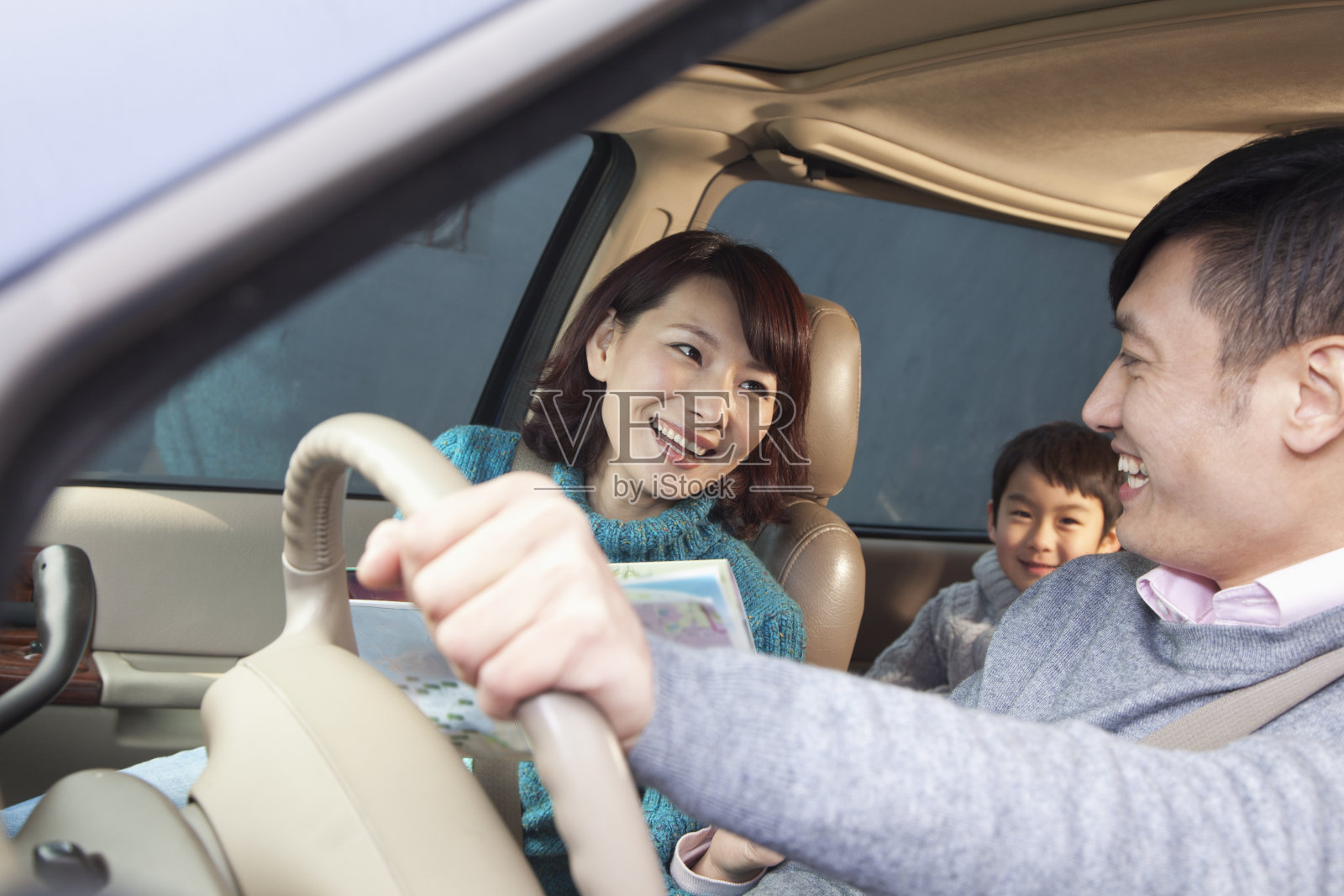 一家人坐在北京的车里，开怀大笑照片摄影图片