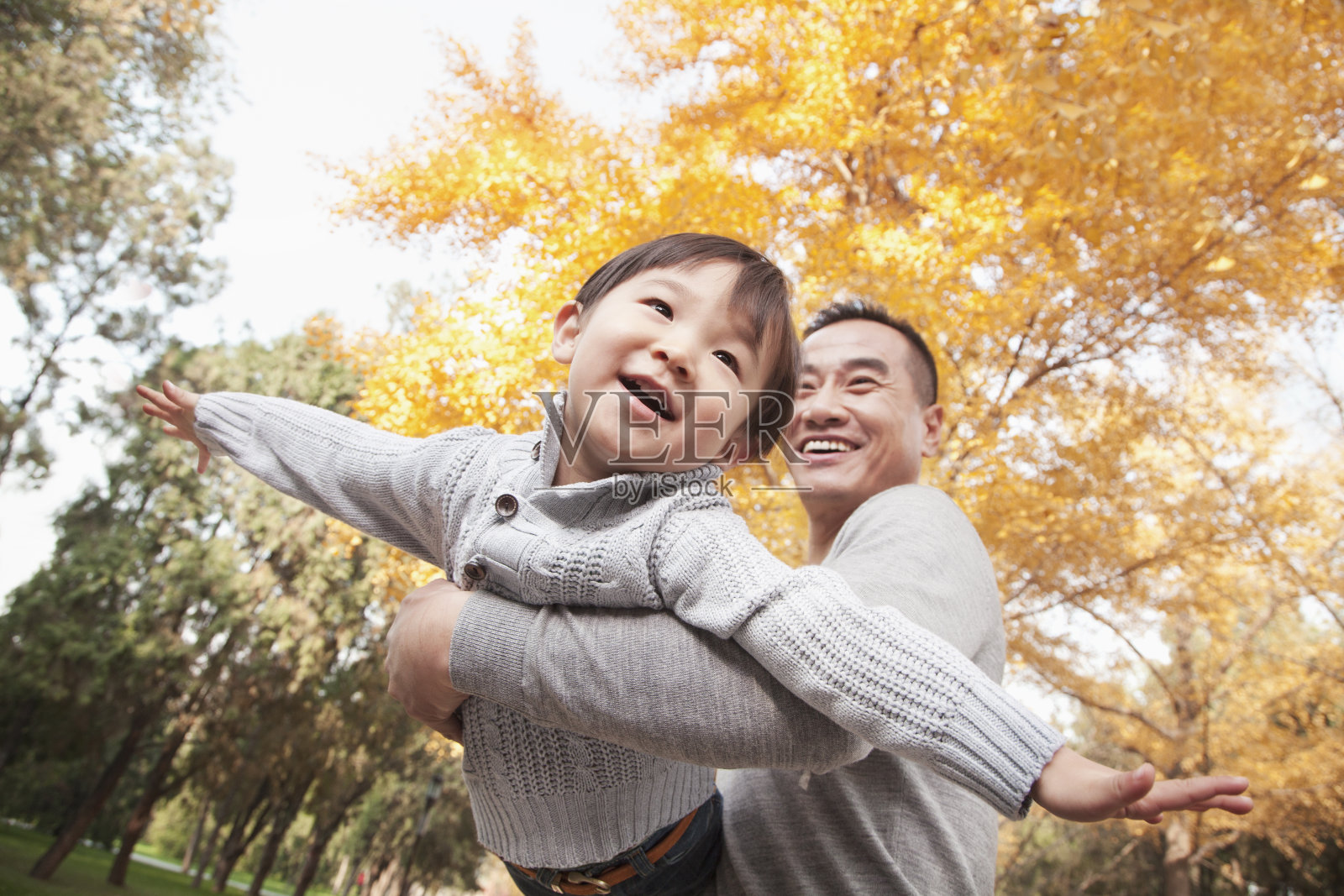 父亲和儿子一起在公园里玩秋天照片摄影图片