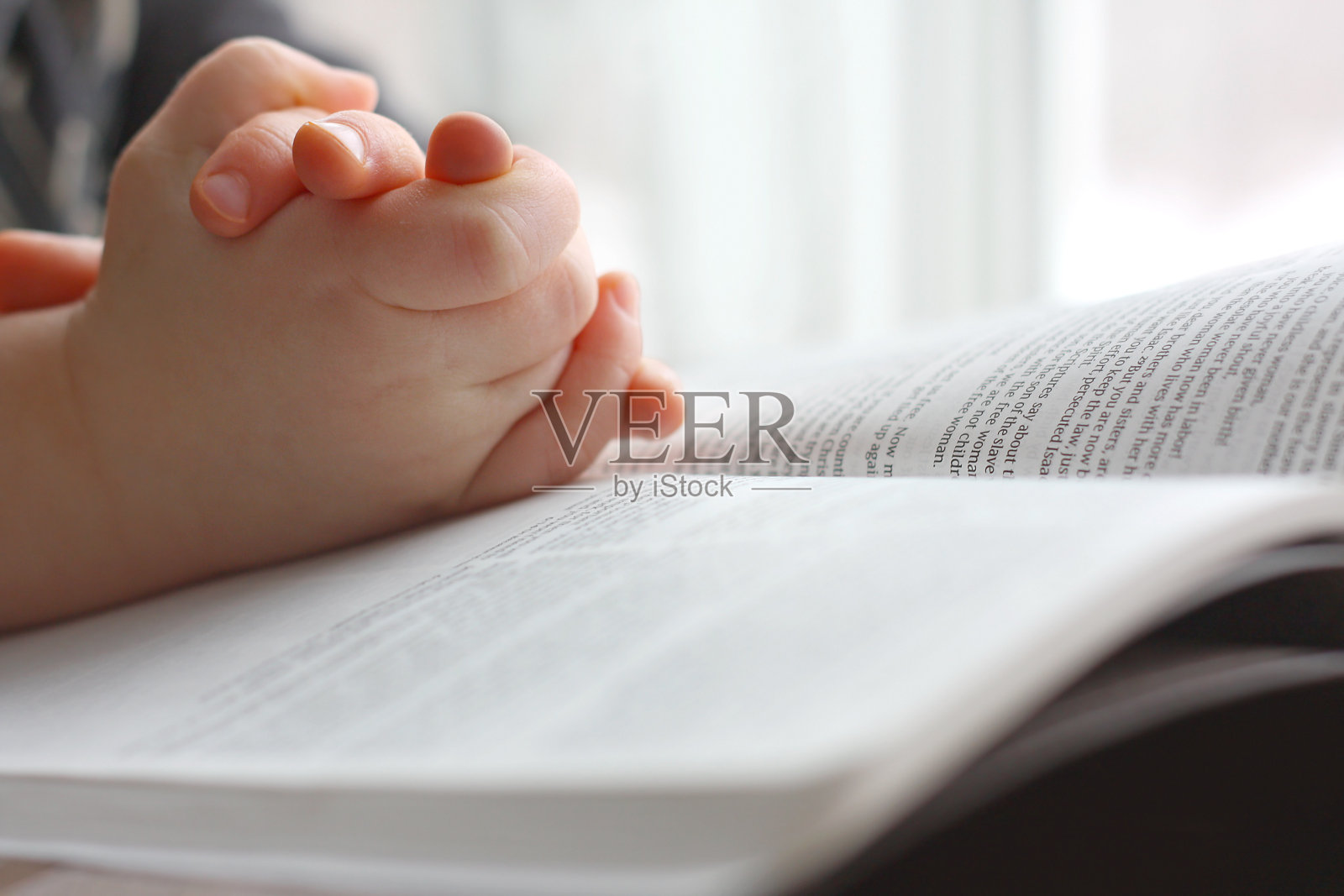 小孩的手在圣经上祈祷照片摄影图片