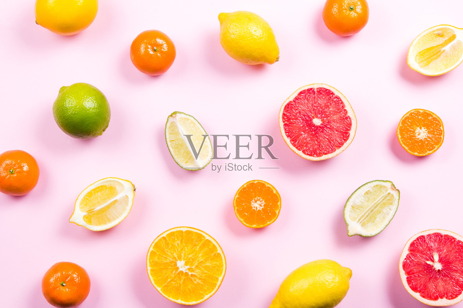 几种完整的和切开的柑橘在粉红色的背景上照片摄影图片
