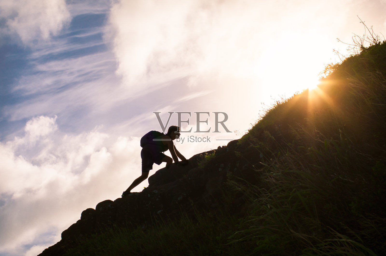 一个年轻人正在爬山。照片摄影图片