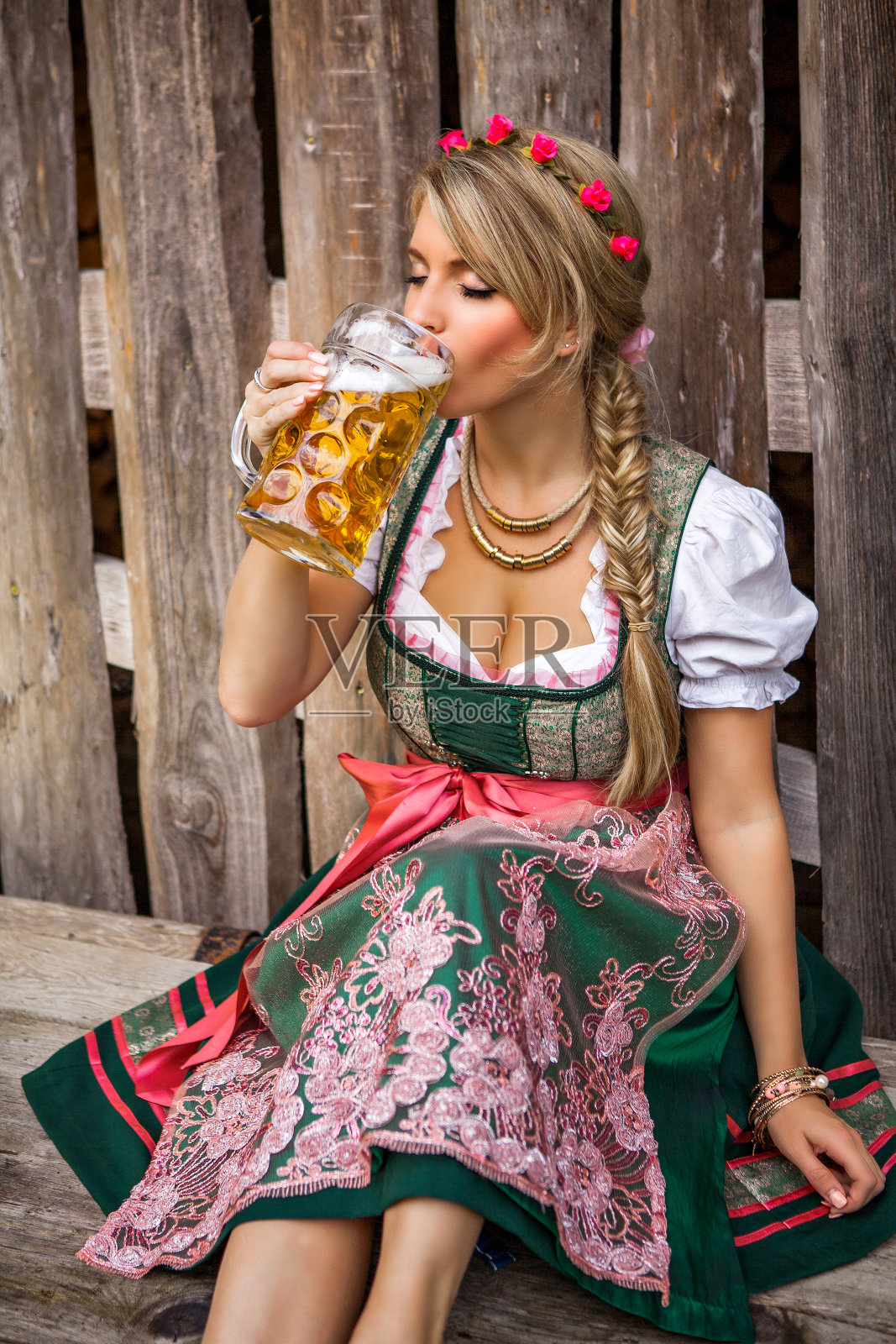 年轻的啤酒节金发女人穿着紧身连衣裙和啤酒照片摄影图片