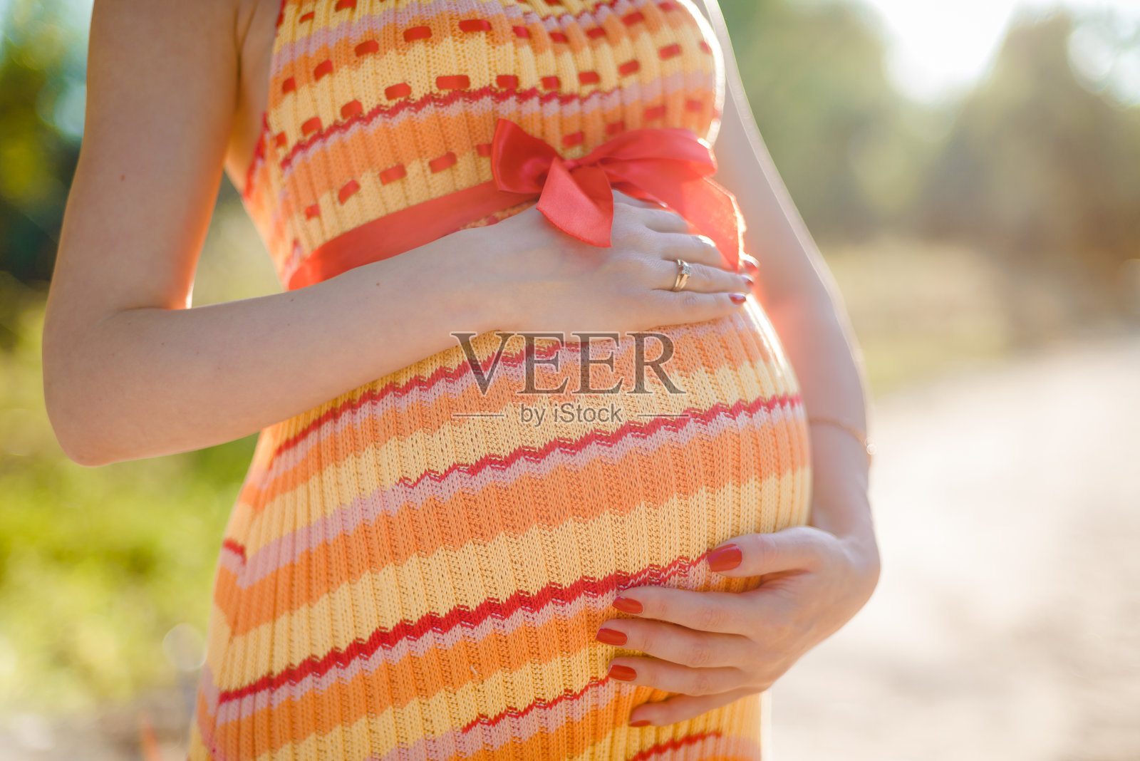 抱着肚子的孕妇，特写照片摄影图片