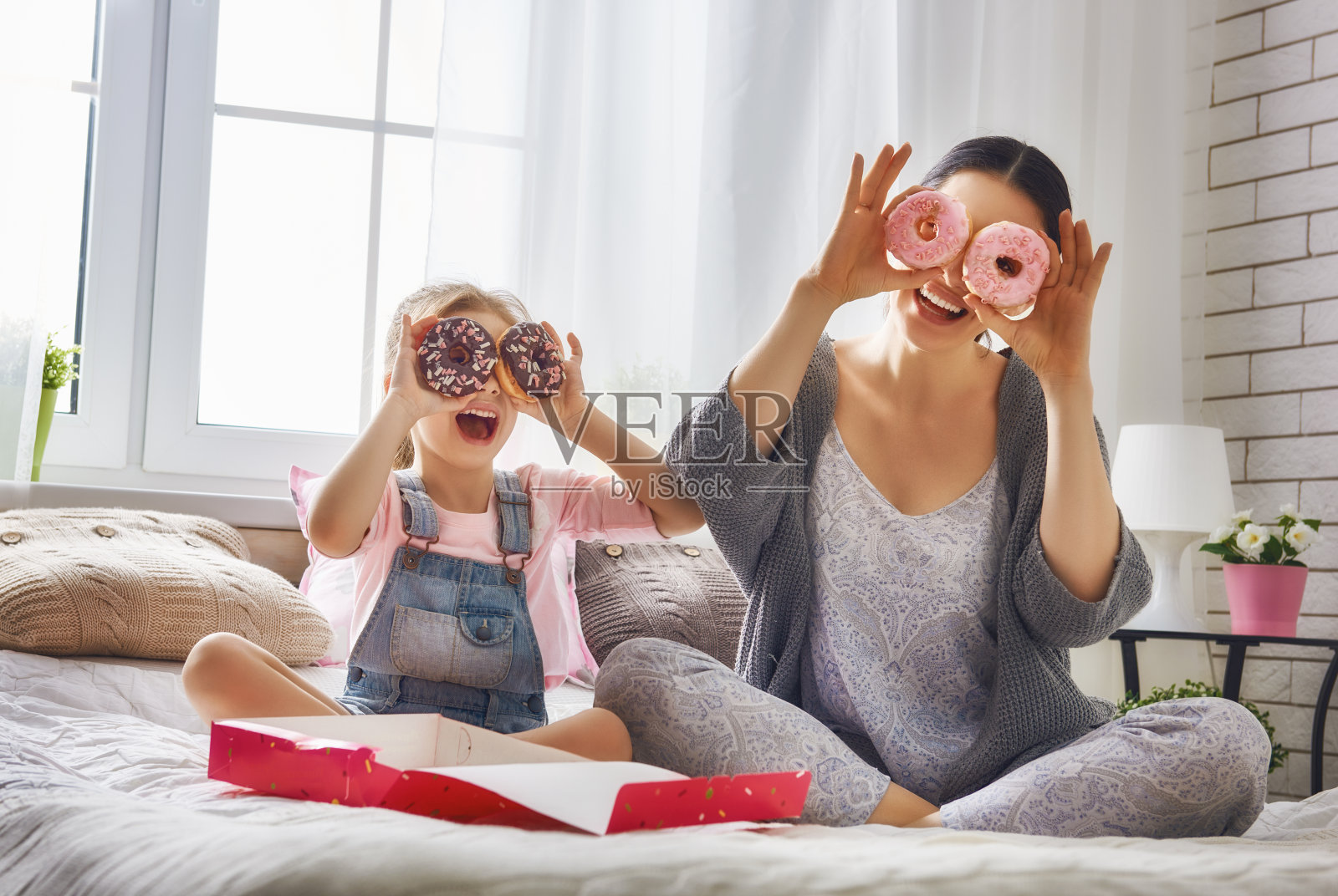妈妈和她的女儿在吃甜甜圈照片摄影图片