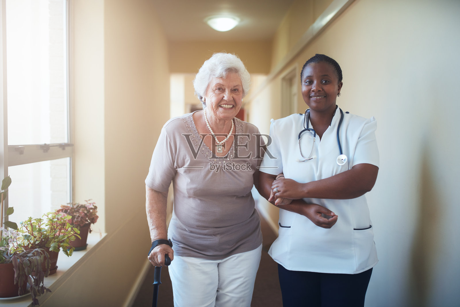 协助老年病人走路的护士照片摄影图片