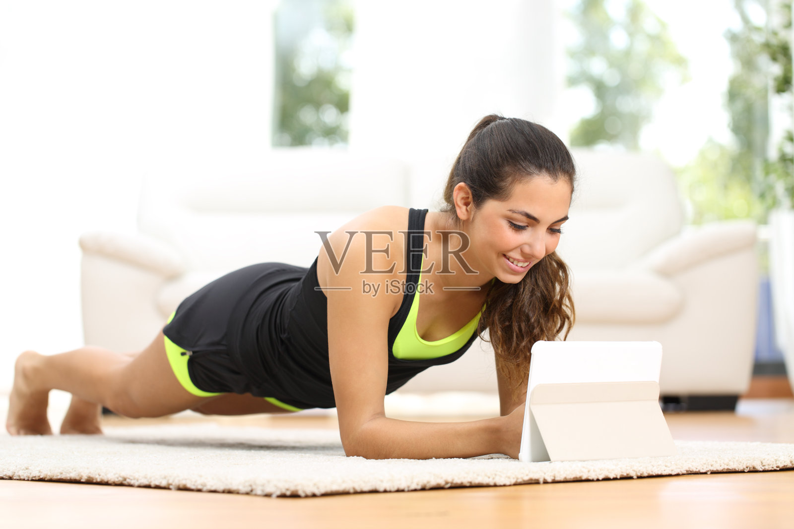 健身女性看健身视频锻炼身体照片摄影图片