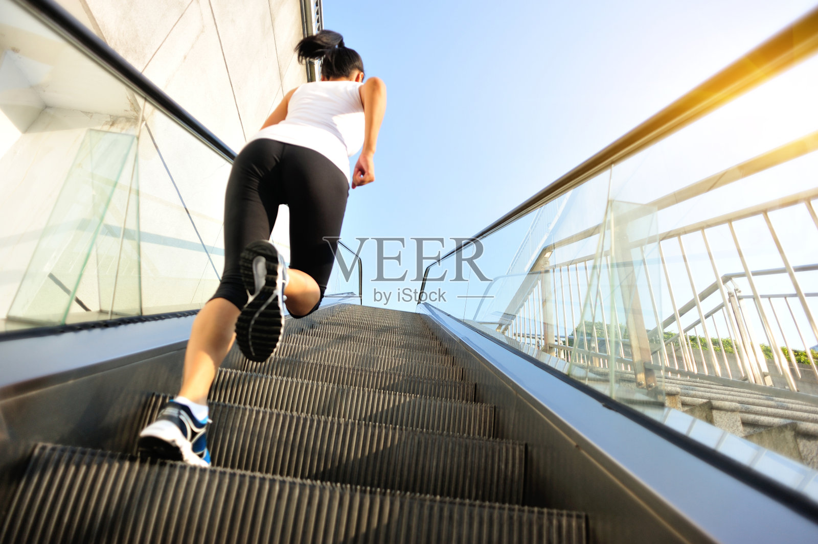 跑步运动员在自动扶梯楼梯上跑步。照片摄影图片