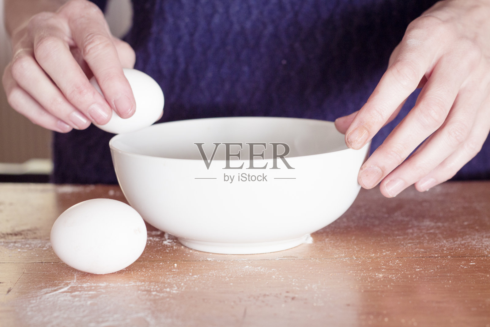 两只手在碗上打碎一个鸡蛋照片摄影图片