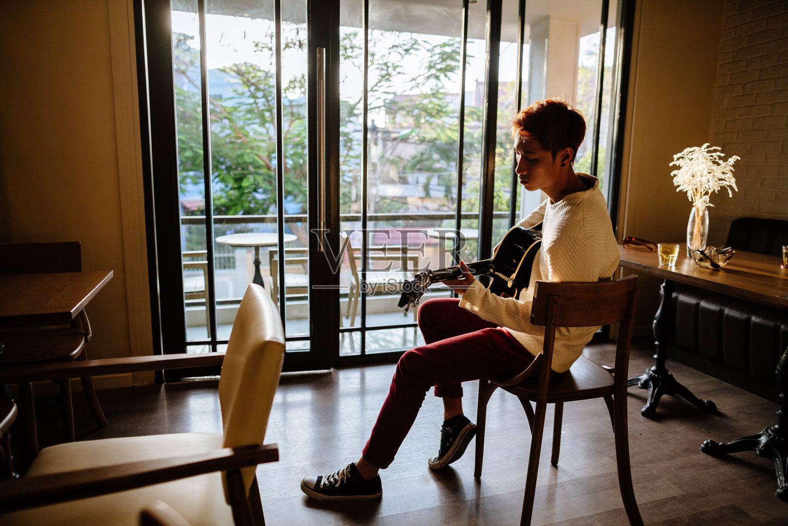 亚洲吉他手艺术家在咖啡馆弹吉他照片摄影图片