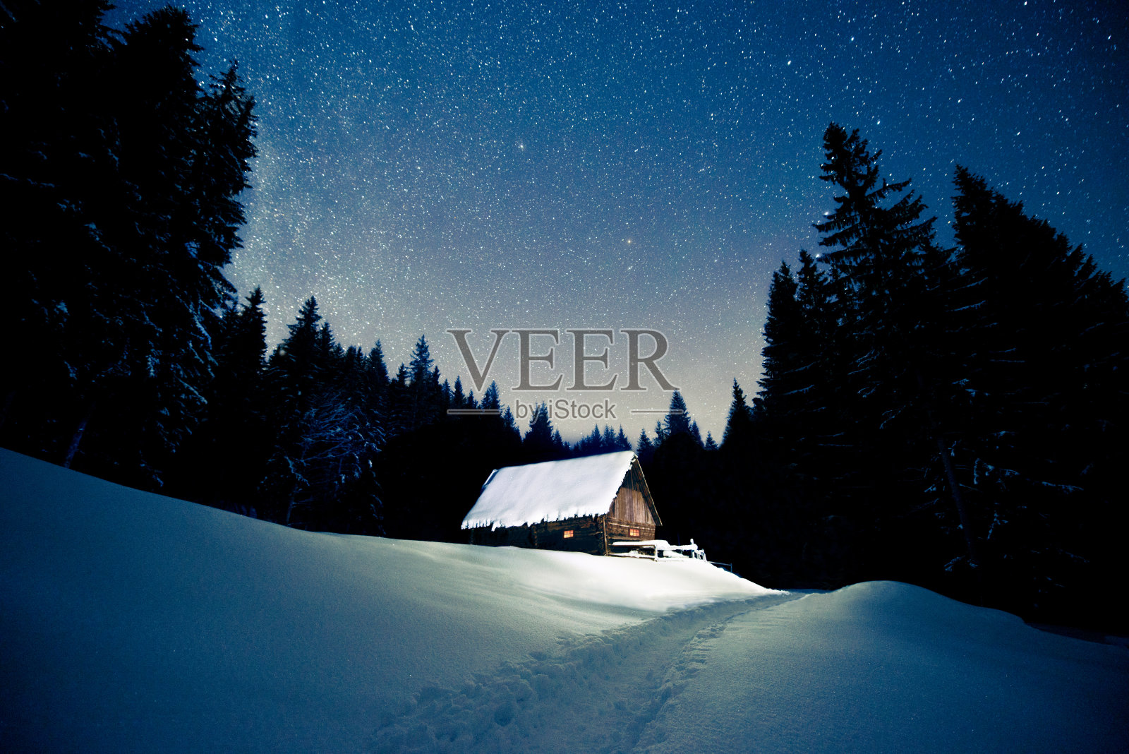 美丽的木屋，在冬天的森林里，在星空下照片摄影图片