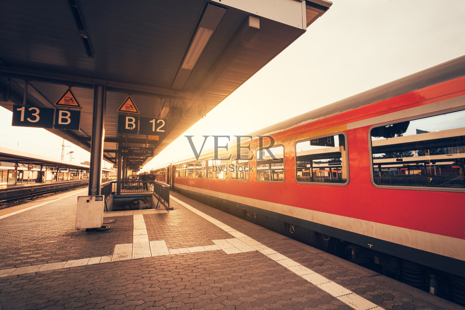 美丽的火车站，日落时分有现代化的红色通勤列车照片摄影图片