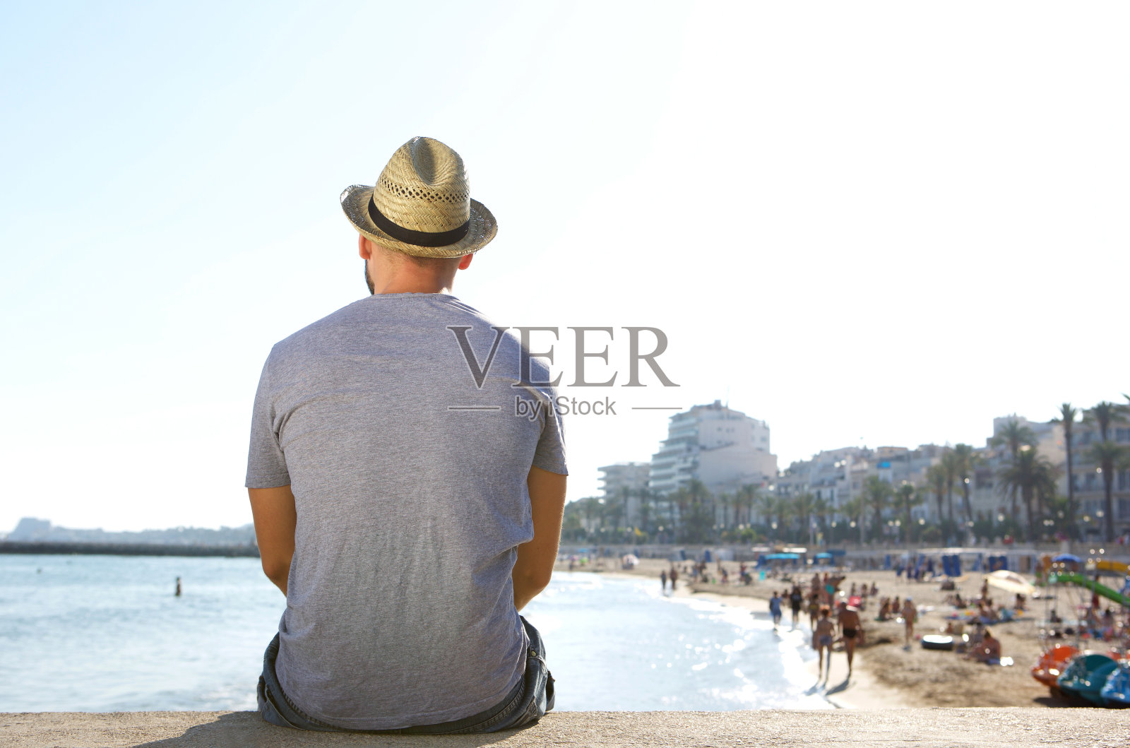 一个男人独自坐着看海滩照片摄影图片