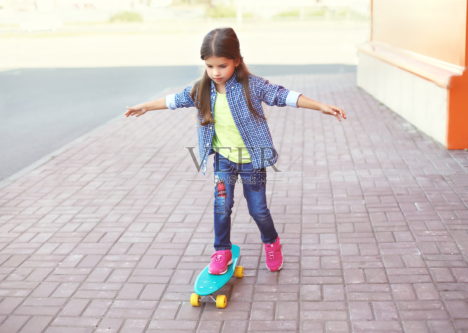 时尚小子，在城市里玩滑板的小女孩照片摄影图片