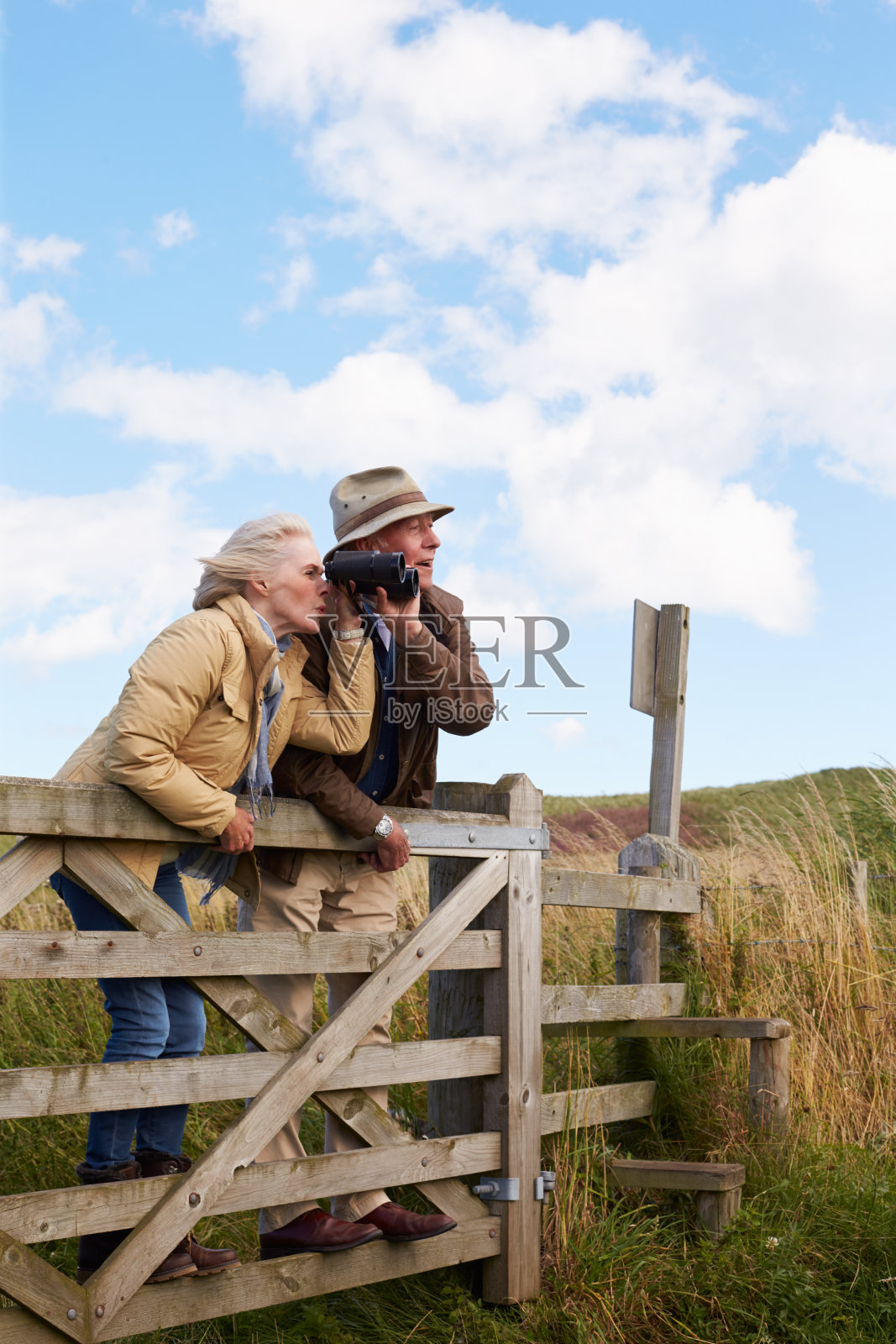 戴双筒望远镜的老夫妇在乡间散步照片摄影图片