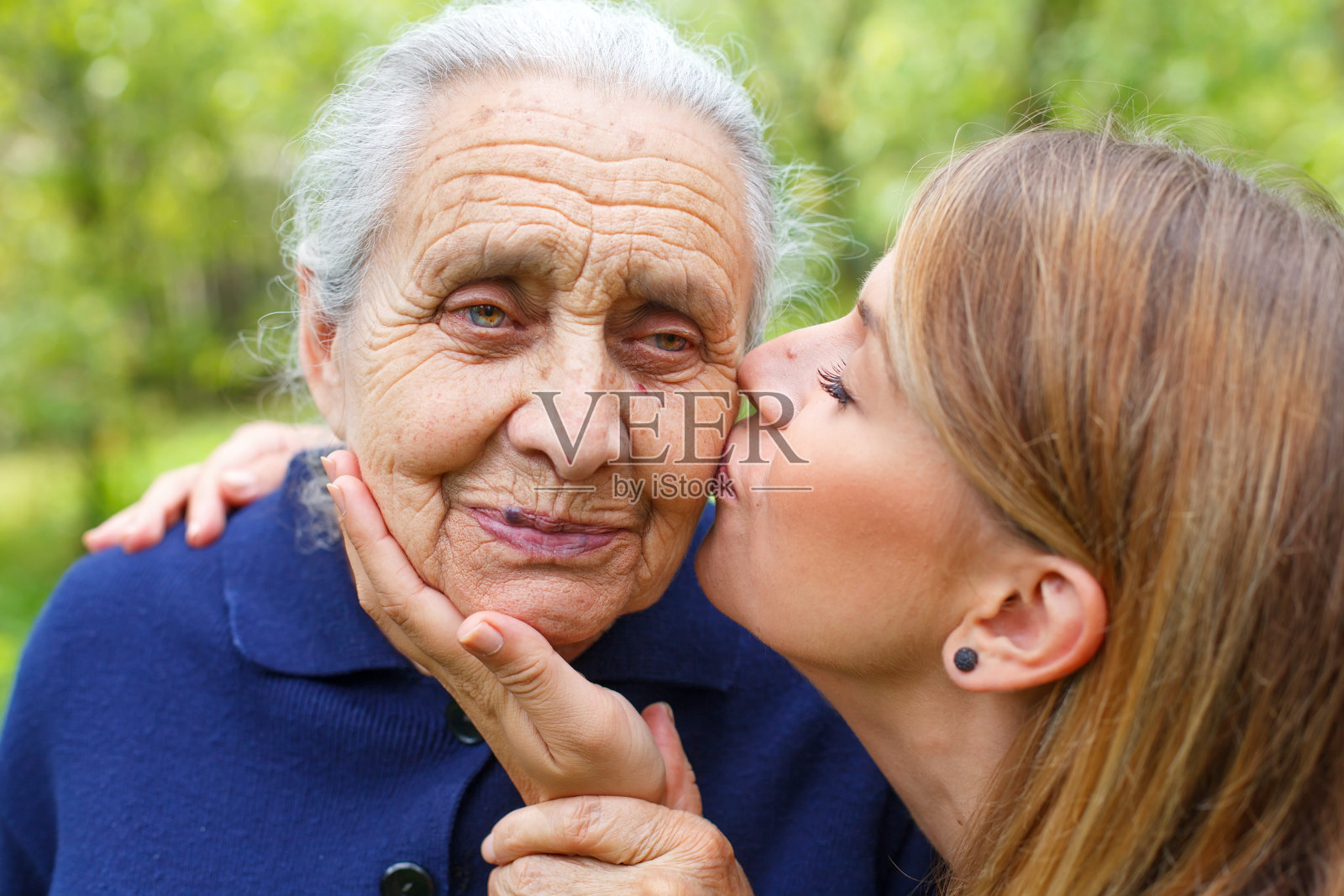 年轻女子亲吻她美丽的奶奶照片摄影图片