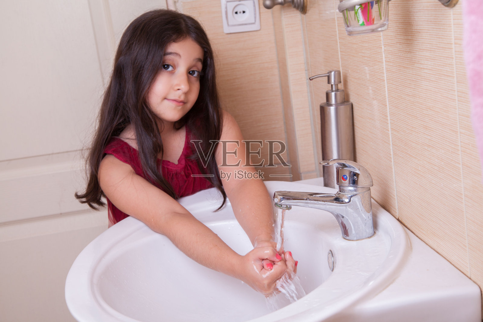 一个穿着红裙子的漂亮女孩正在洗手照片摄影图片