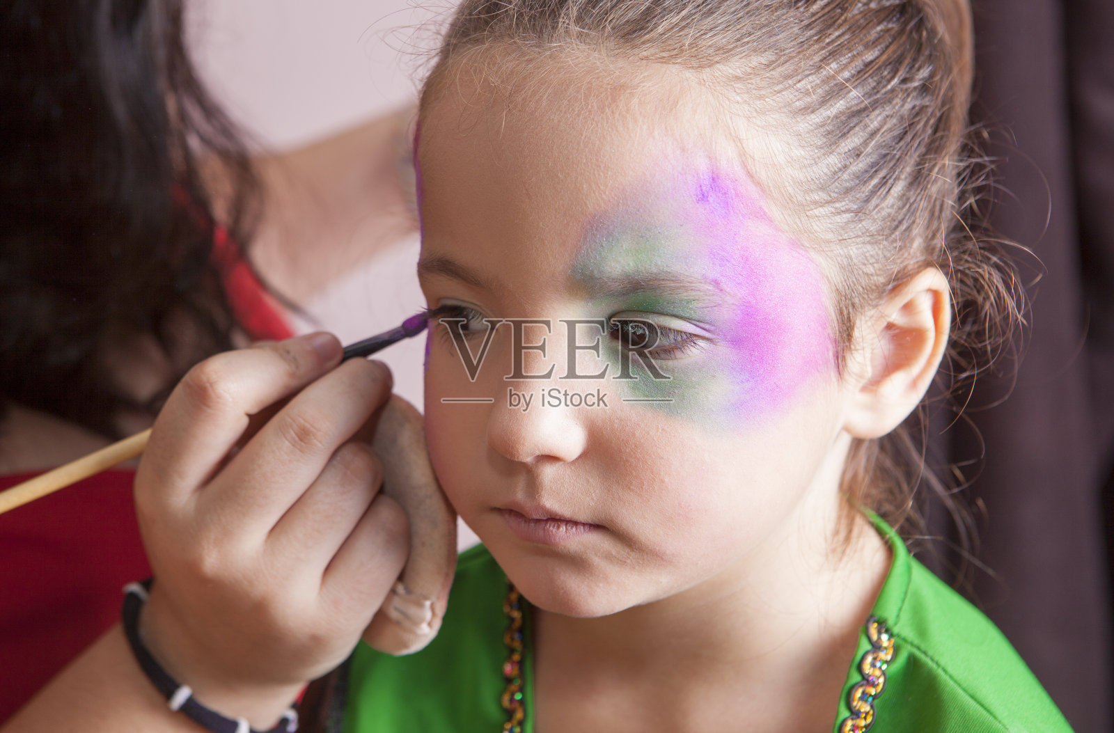 万圣节前夕，可爱的小女孩在做脸部彩绘照片摄影图片