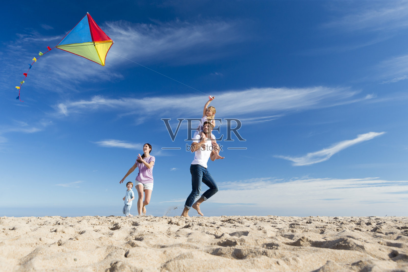 一家人在海滩上放风筝照片摄影图片