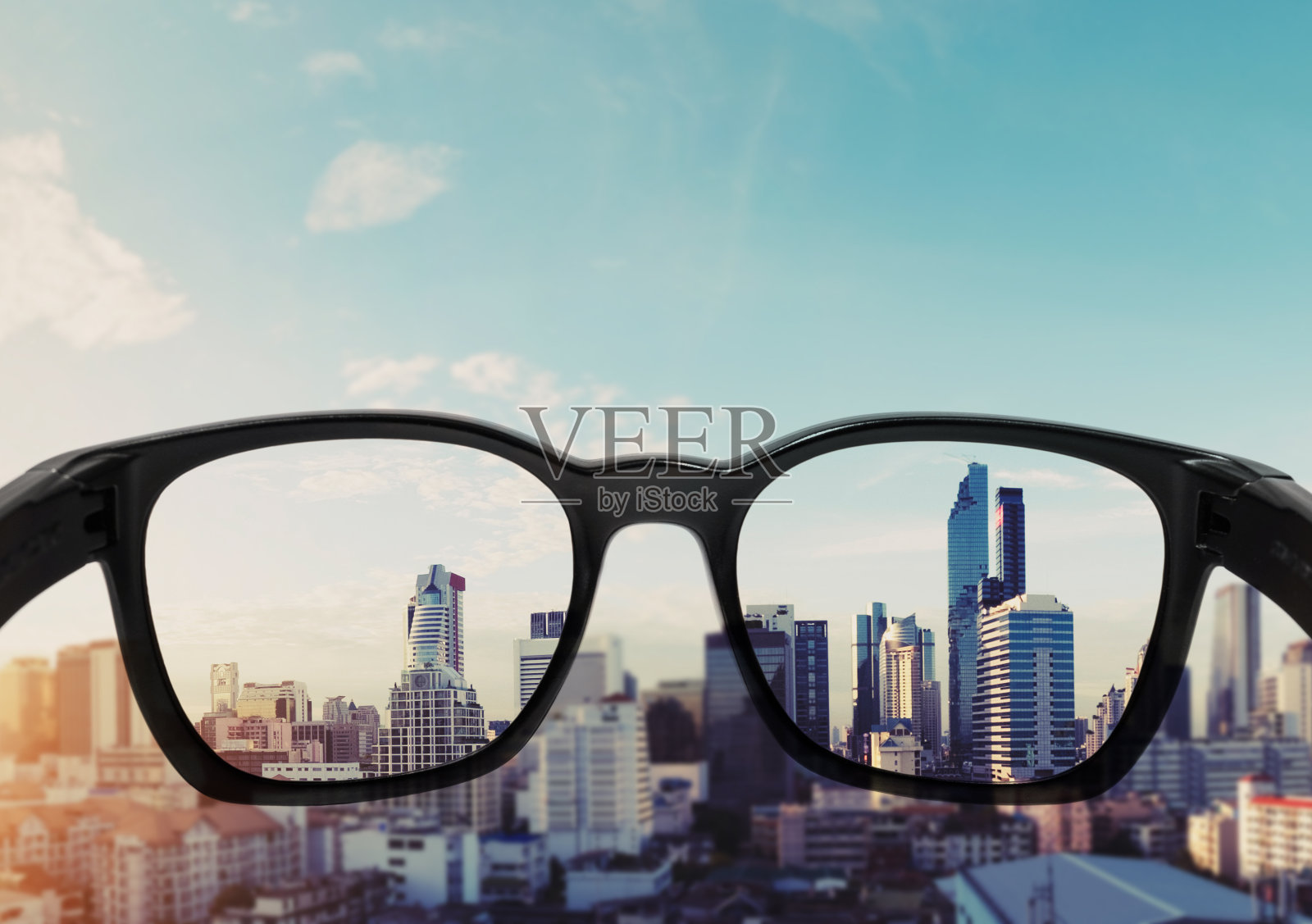 眼镜望向城市，聚焦眼镜镜片照片摄影图片