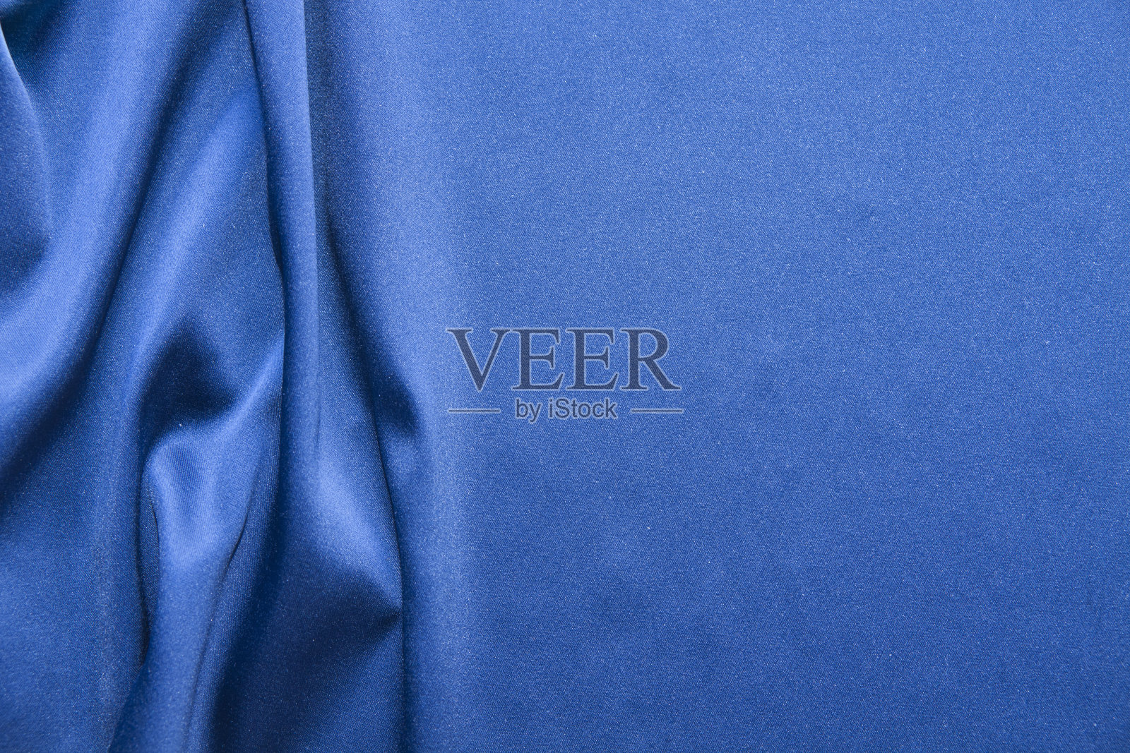 蓝色丝绸背景。抽象的波浪纹理照片摄影图片