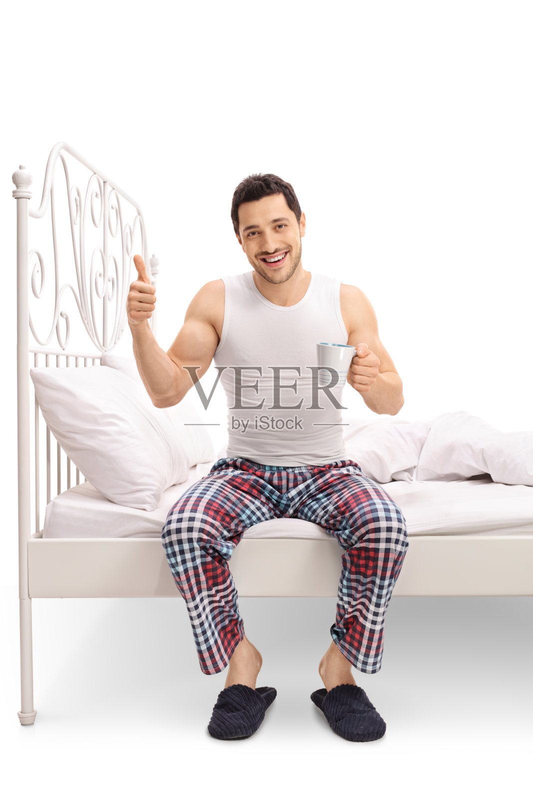 男人在床上拿着杯子，竖起大拇指照片摄影图片