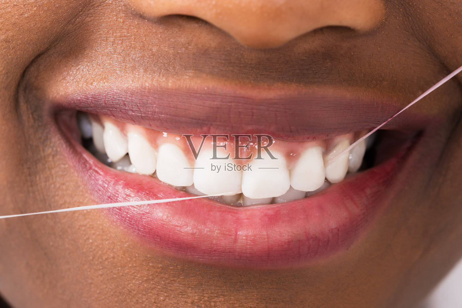 非洲妇女用牙线清洁牙齿照片摄影图片