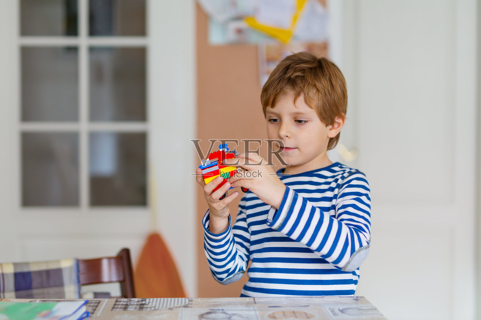 小男孩在玩五颜六色的小塑料积木照片摄影图片