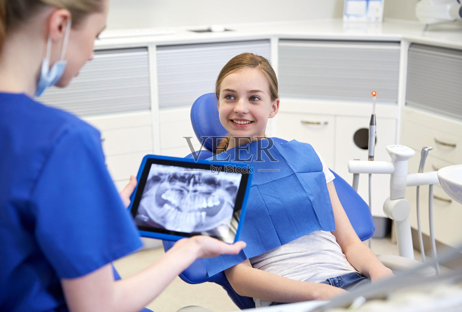 用平板电脑拍x光片的牙医和病人女孩照片摄影图片
