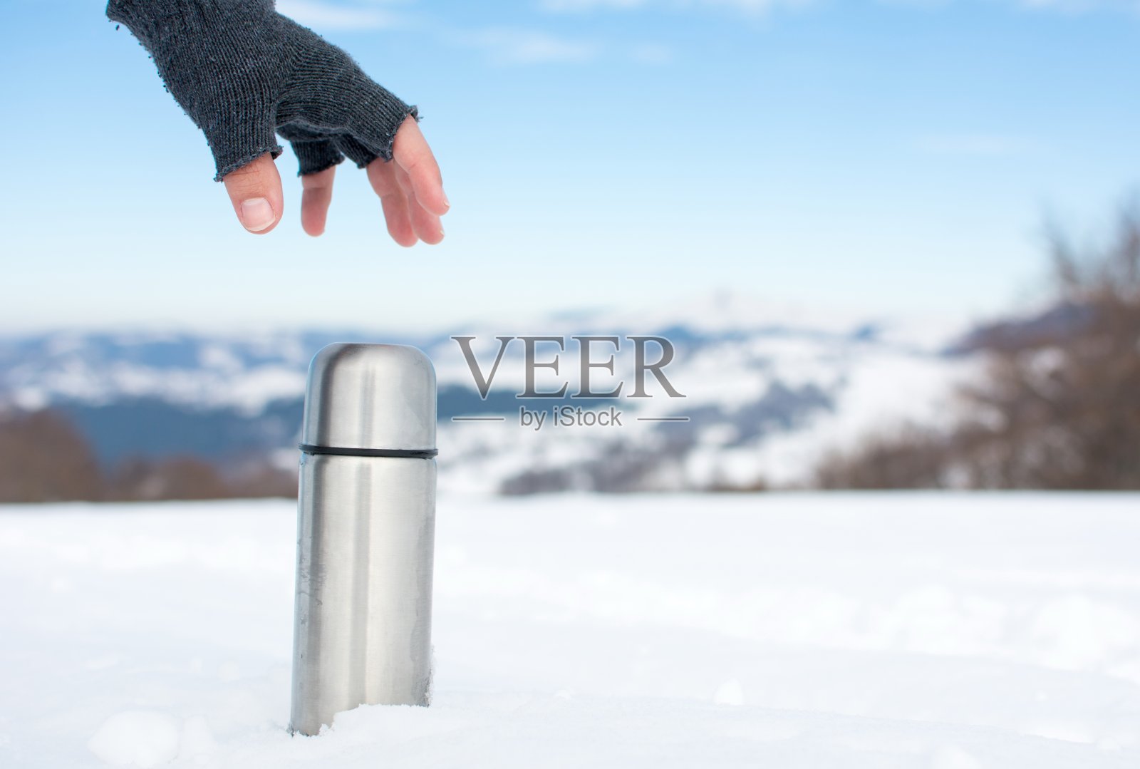 在雪山上拿着热水瓶的人照片摄影图片
