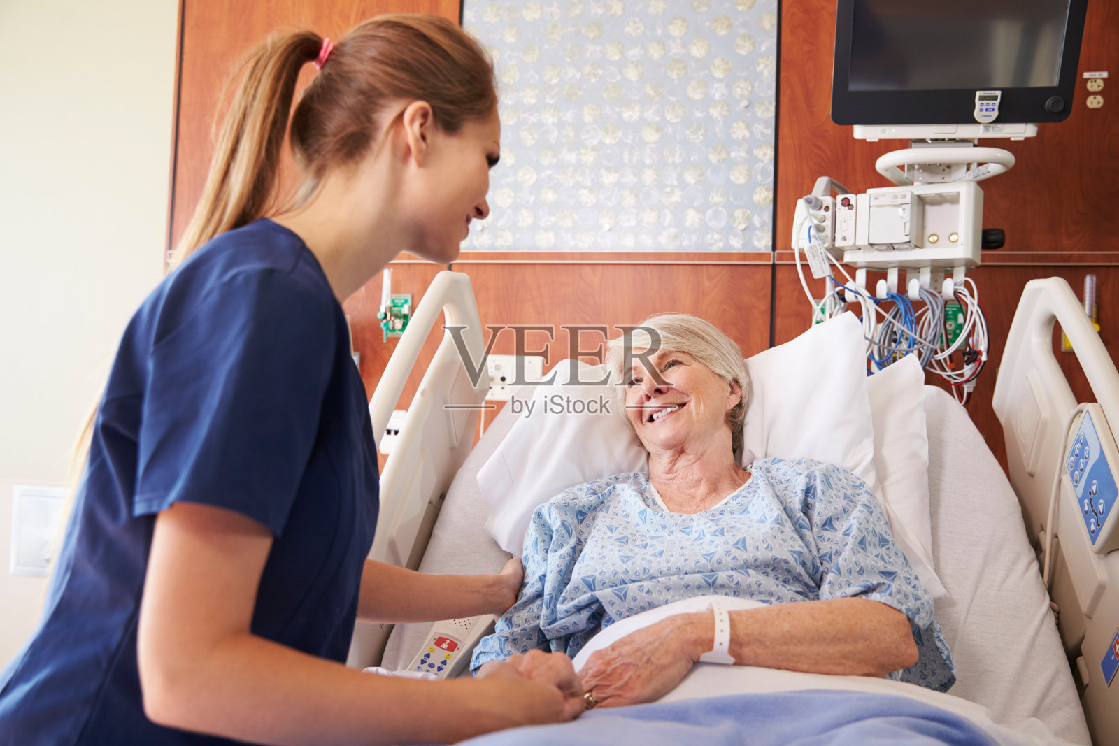 护士在病床上对老年女病人谈话照片摄影图片