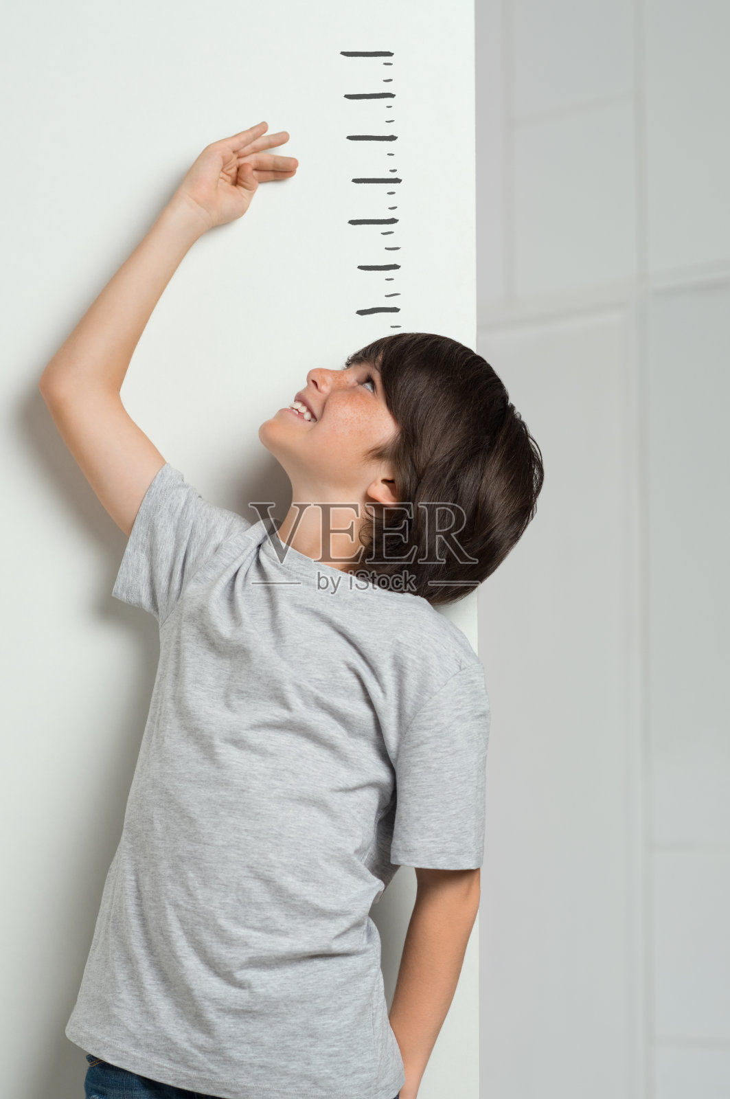 男孩测量他的身高照片摄影图片