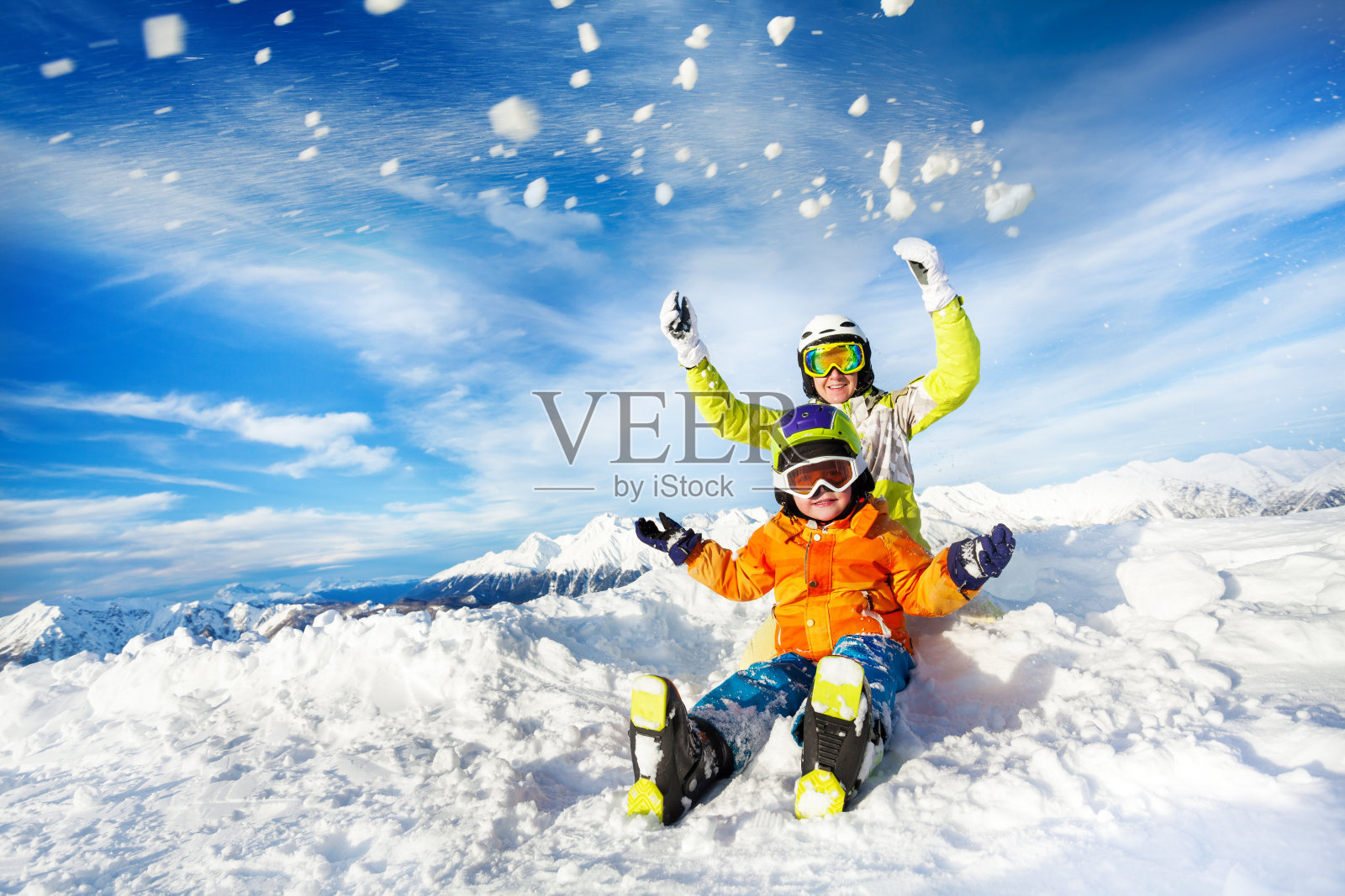 母亲和儿子在山上快乐的抛雪照片摄影图片