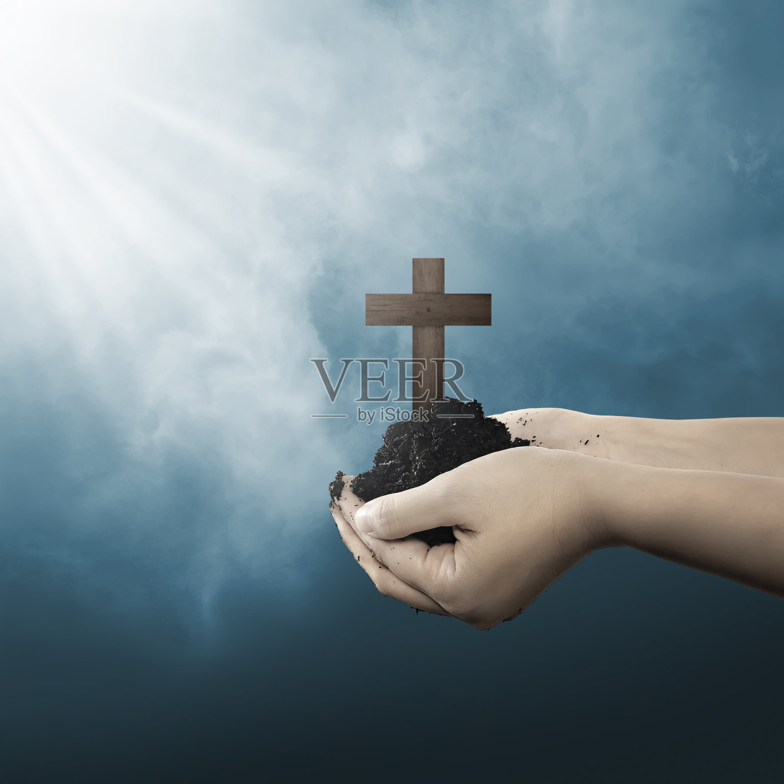 人的手握着基督教十字架，手上有泥土照片摄影图片