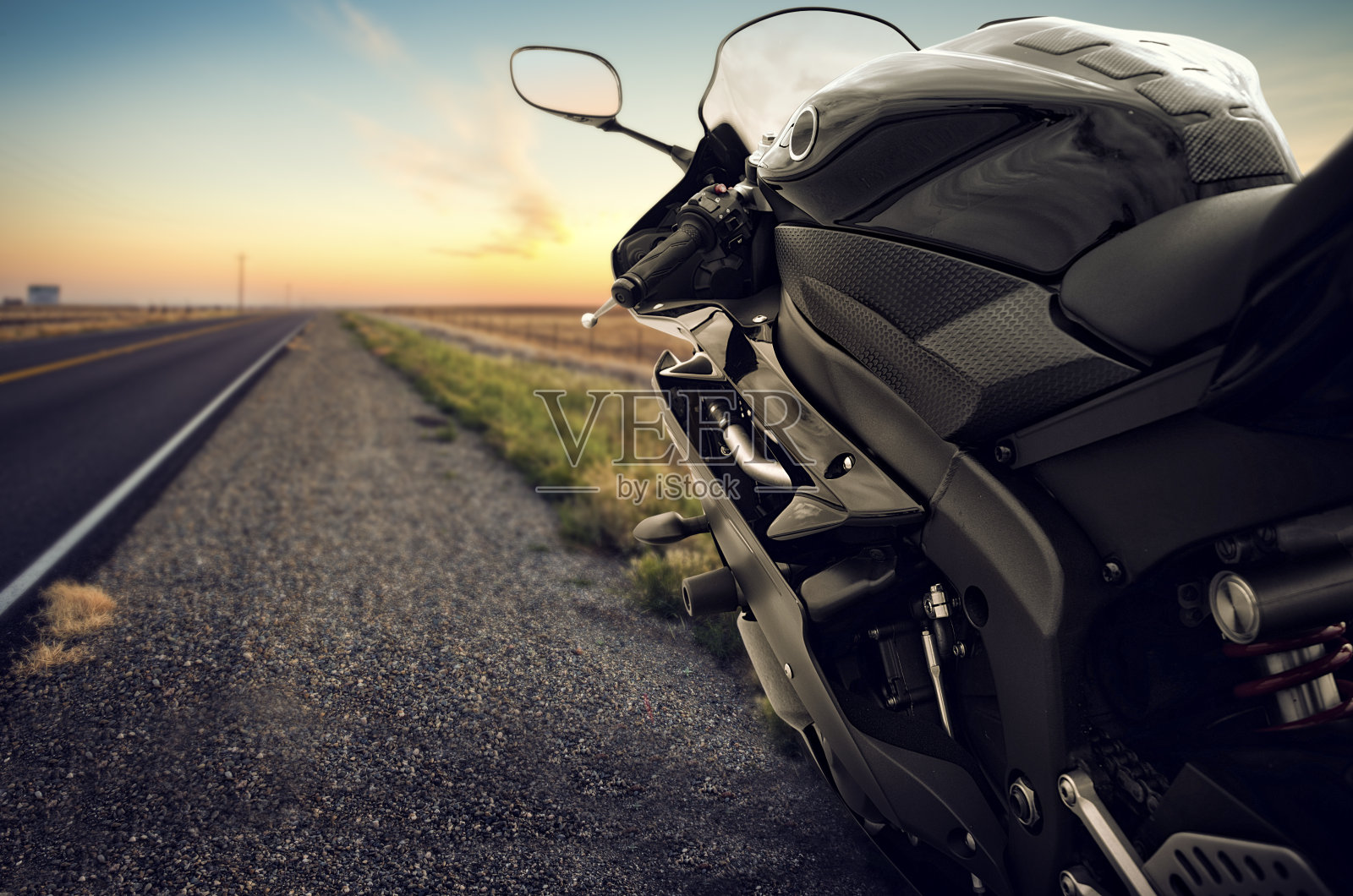 日落时分，摩托车在空旷的路上行驶照片摄影图片