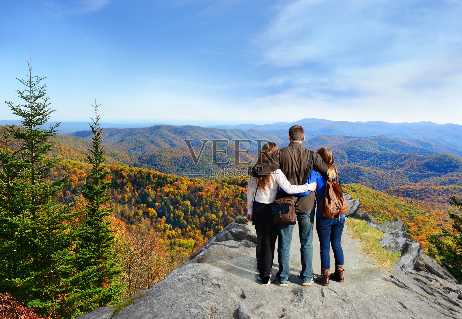 全家在秋天的山上远足。照片摄影图片