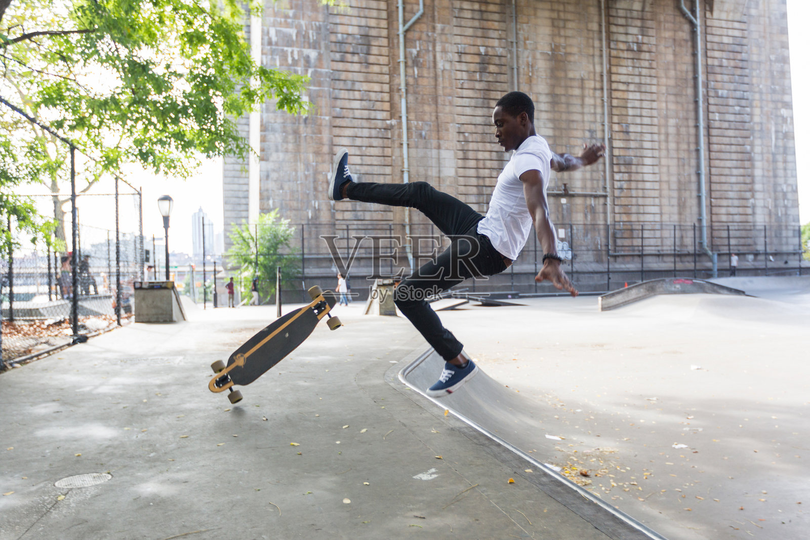 黑人男孩在公园滑冰和摔倒照片摄影图片