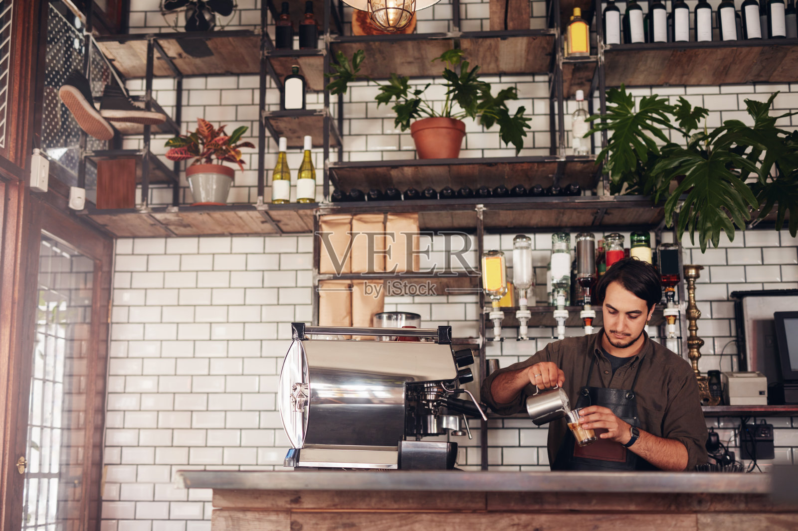 年轻的男咖啡师正在煮咖啡照片摄影图片