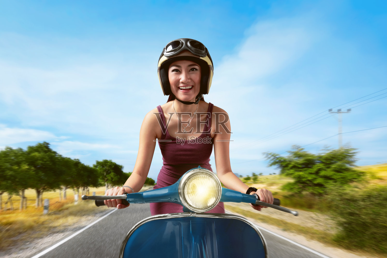 迷人的亚洲女人骑着蓝色的踏板车照片摄影图片