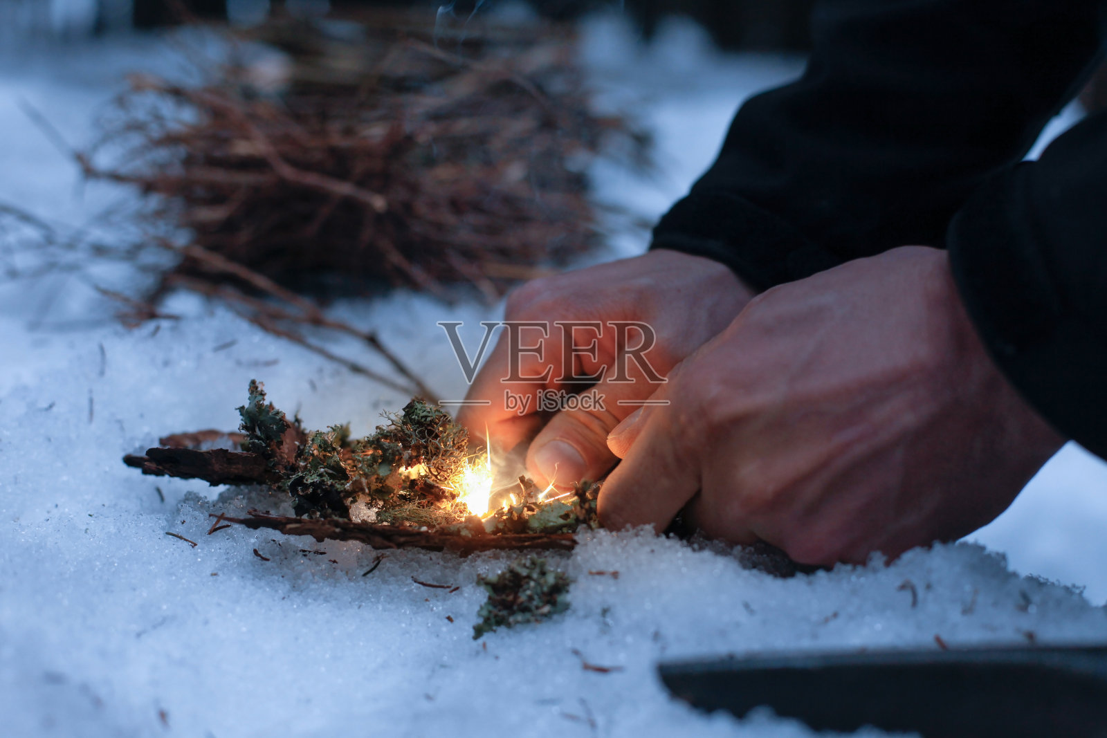 人们在黑暗的冬天的森林里生火照片摄影图片