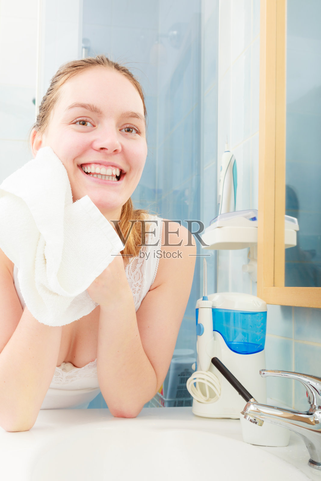 在浴室里用清水洗脸的女人照片摄影图片