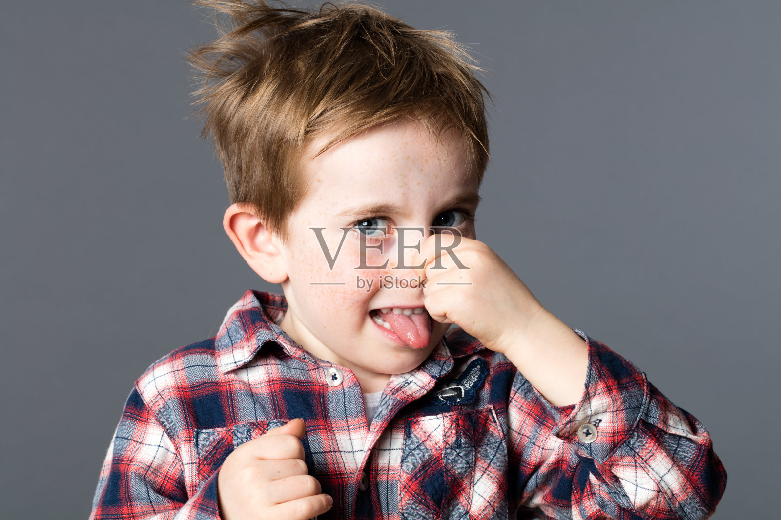 小男孩捏着自己的鼻子，表示有异味照片摄影图片