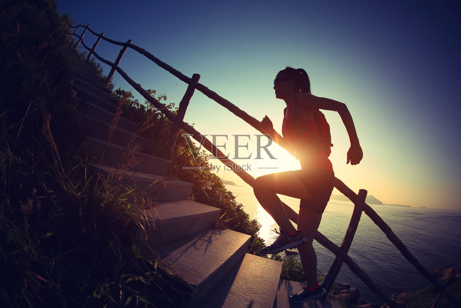 年轻的健身女运动员在山上的楼梯上跑步照片摄影图片