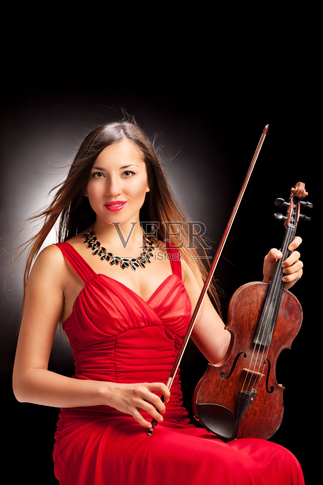 一个女小提琴手摆姿势的垂直镜头照片摄影图片