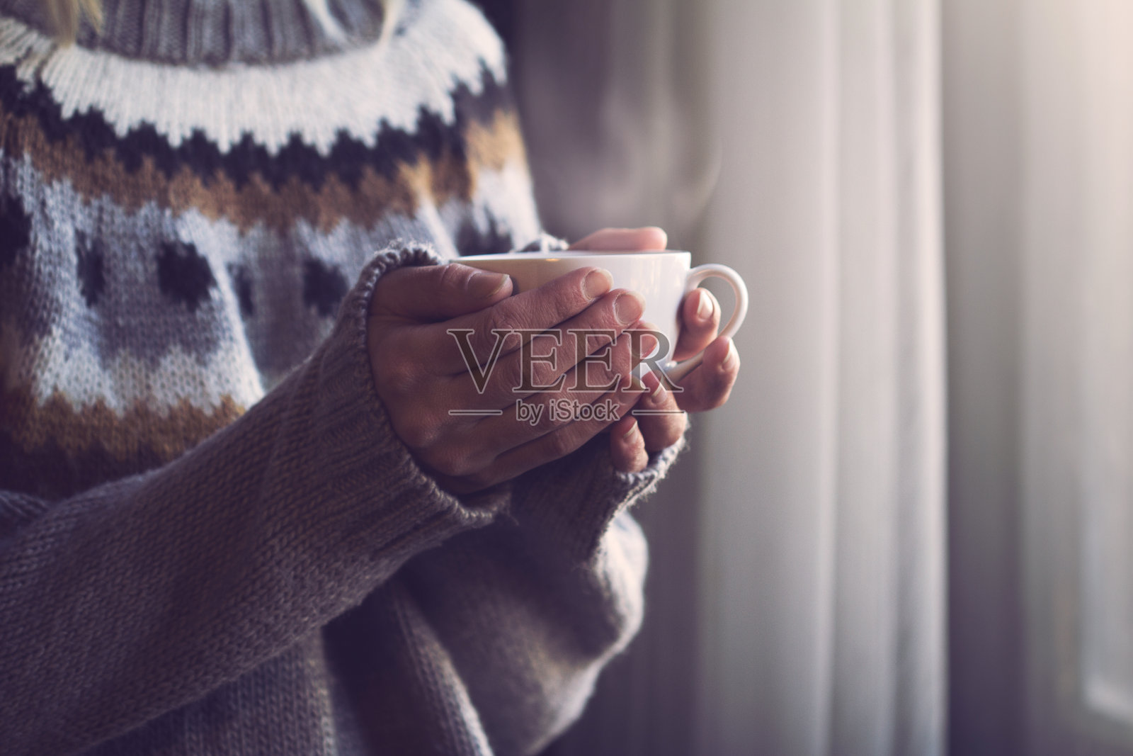 穿着针织毛衣的女人手里拿着一杯热咖啡照片摄影图片