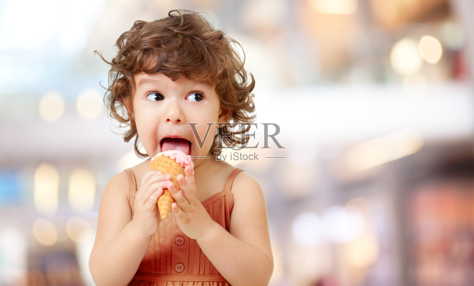 孩子们在吃冰淇淋。可爱的卷毛小孩吃冰淇淋。照片摄影图片