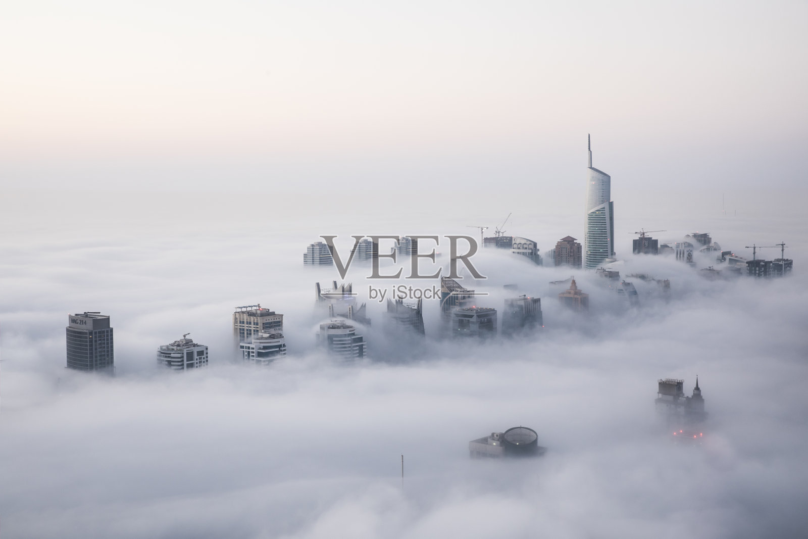 罕见的冬日晨雾笼罩着迪拜的摩天大楼。照片摄影图片